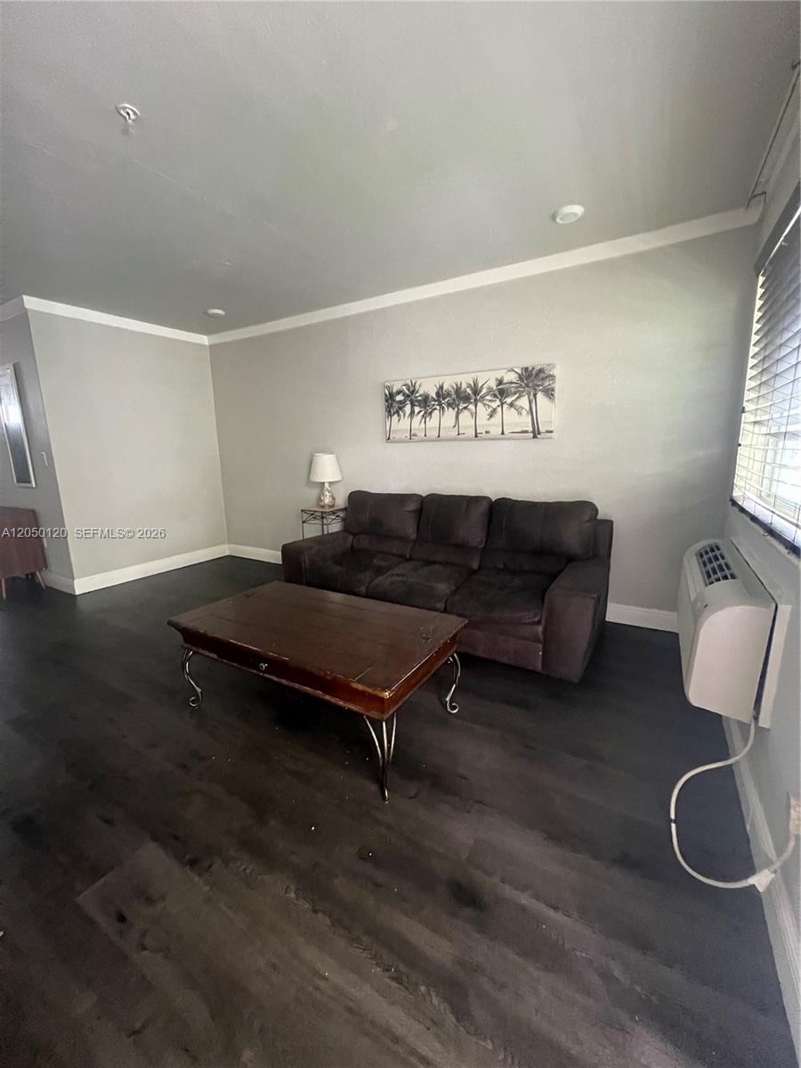 A living room features dark wood-look flooring, a brown sofa, and a coffee table — 1524 Lenox Ave # 11, Miami Beach FL 33139, MIAMI BEACH, FL