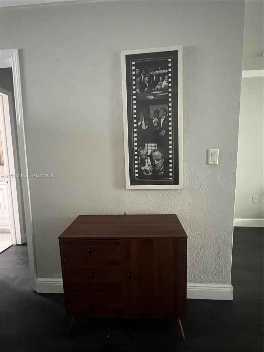 A wooden cabinet sits against a gray wall beneath a framed film strip poster — 1524 Lenox Ave # 11, Miami Beach FL 33139, MIAMI BEACH, FL