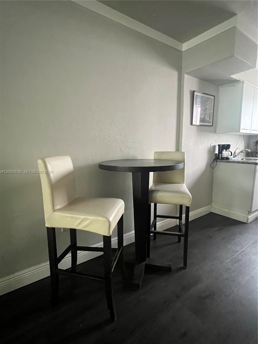 A small dining area features a round black table and two cream-colored bar stools — 1524 Lenox Ave # 11, Miami Beach FL 33139, MIAMI BEACH, FL