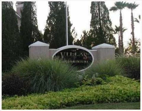 A sign for The Villas Condominiums stands in front of landscaping and tall trees — 10561 VILLA VIEW CIRCLE UNIT 10561, TAMPA, FL