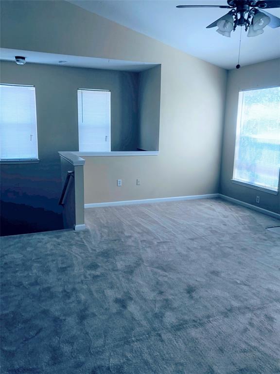 This carpeted loft area features a vaulted ceiling, a ceiling fan, and a stairwell railing — 10561 VILLA VIEW CIRCLE UNIT 10561, TAMPA, FL