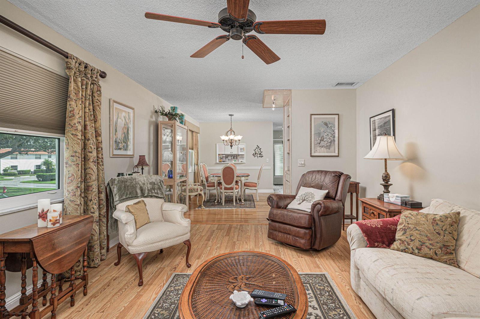 A living room with wood flooring, a ceiling fan, and an adjacent dining area — 1225 NW 21st Street # 708, Stuart FL 34994, STUART, FL