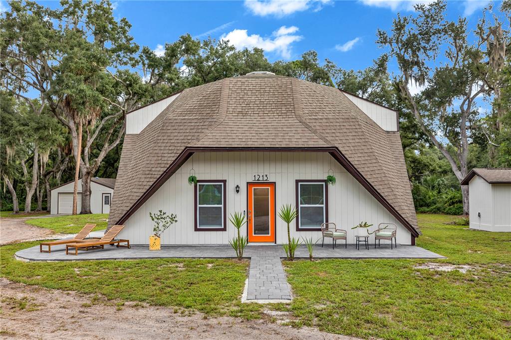 A unique dome-shaped house with a shingled roof, white siding, and an orange front door — 1213 BUTCH CASSIDY TRAIL, WIMAUMA, FL