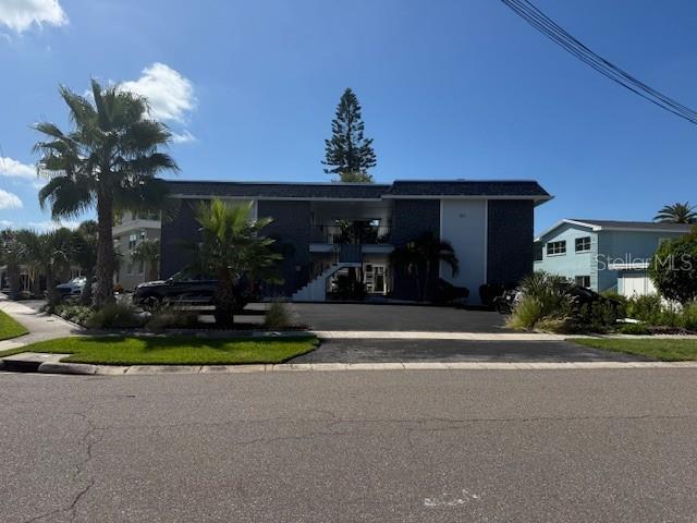 A stone picnic table sits on a grassy lawn overlooking a canal with docked boats — 430 LARBOARD WAY UNIT 3, CLEARWATER BEACH, FL