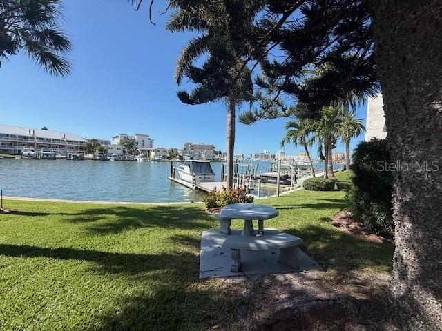 A two-story apartment building with dark siding and a parking lot sits under a blue sky — 430 LARBOARD WAY UNIT 3, CLEARWATER BEACH, FL
