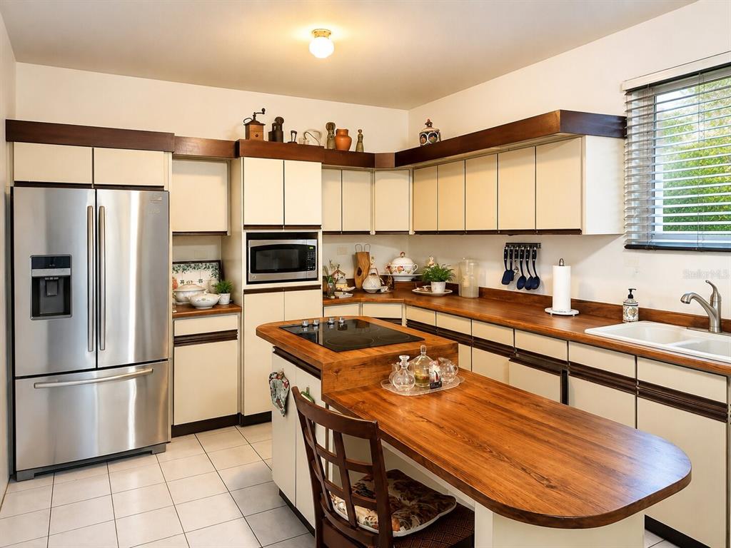 A kitchen with white cabinets, wood countertops, a center island, and stainless steel appliances — Calle B# 7 URB. MONTE BRISA, GURABO, PR