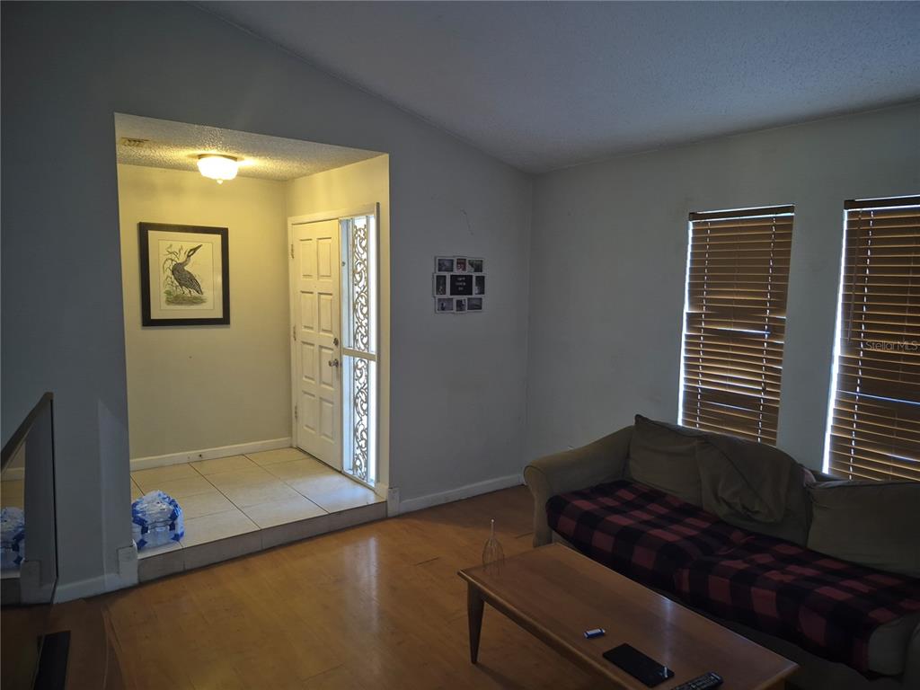 A living room features hardwood floors, a sofa, a coffee table, and an entryway alcove — 13710 WHITBY ROAD, HUDSON, FL