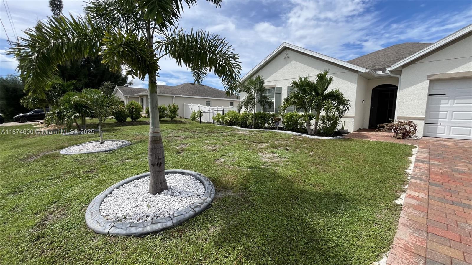 A single-story house with a paved driveway, palm trees, and a landscaped front yard — 2829 NW 7 TERRACE, Cape Coral FL 33993, CAPE CORAL, FL