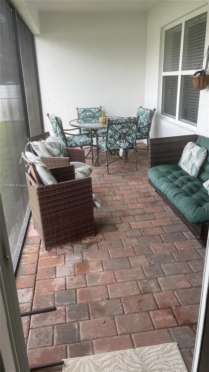 A screened-in patio features brick pavers, a dining set, and wicker lounge furniture — 2829 NW 7 TERRACE, Cape Coral FL 33993, CAPE CORAL, FL