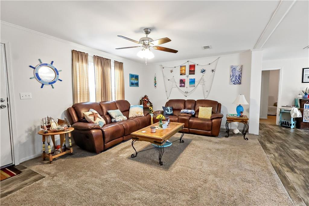 A living room features brown leather sofas, a coffee table, and nautical-themed wall decor — 324 Valencia Street, Sebastian FL 32958, SEBASTIAN, FL