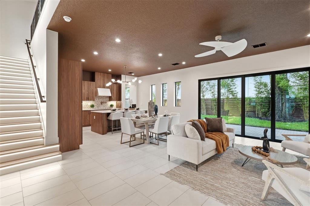 An open-concept living and dining area features a brown ceiling, wood cabinetry, and sliding doors — 1615 COLE ROAD, ORLANDO, FL