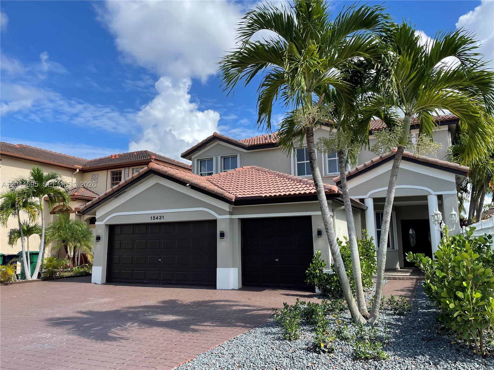 A two-story suburban house features a two-car garage, tile roof, and palm trees — 15431 SW 39th Ter, Miami FL 33185, MIAMI, FL
