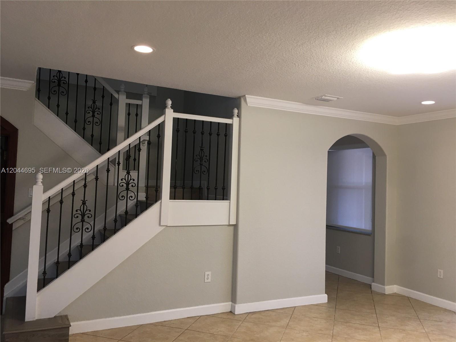 An interior view shows a staircase with decorative metal railings and an arched doorway — 15431 SW 39th Ter, Miami FL 33185, MIAMI, FL