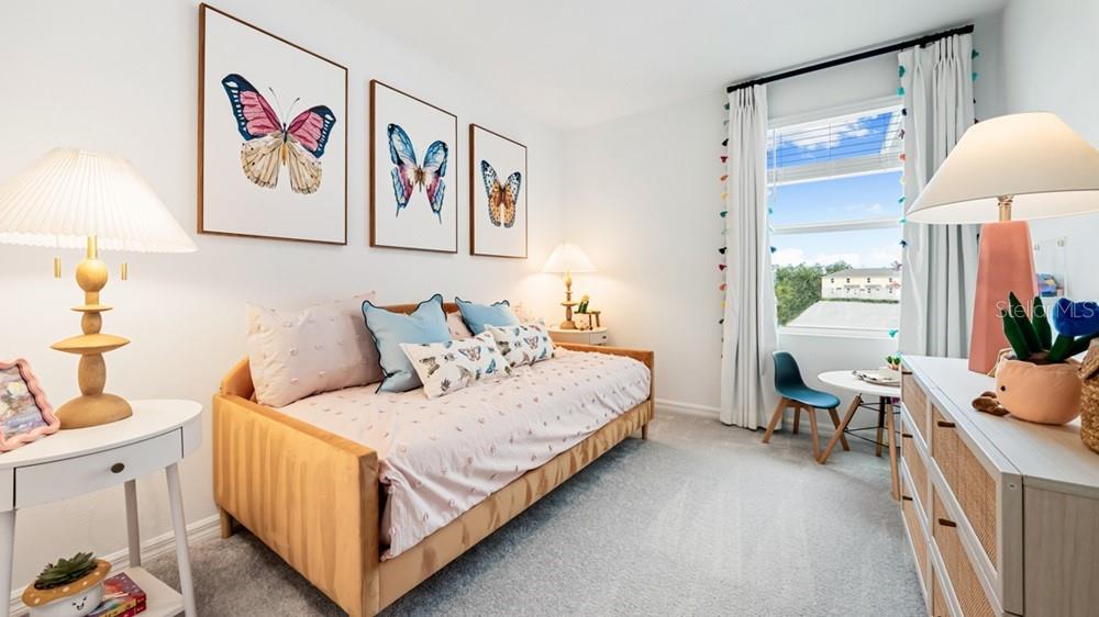 A bedroom features a daybed, butterfly wall art, two lamps, and a window with curtains — 2691 BALMERINO WAY, MOUNT DORA, FL