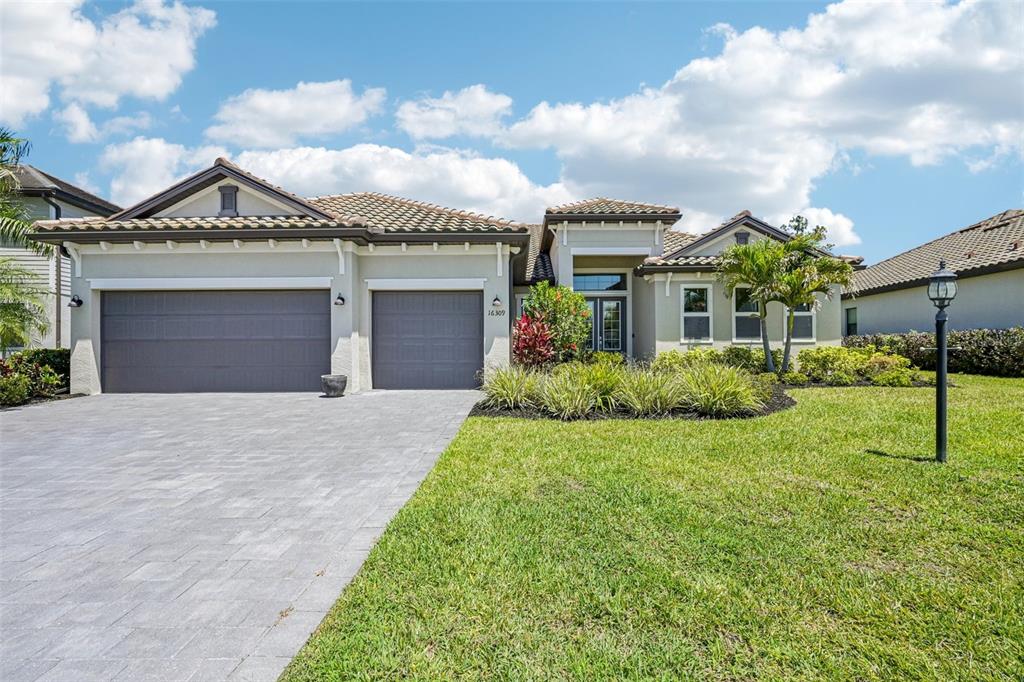 A single-story house with a gray garage, tile roof, and a paved driveway — 16309 TRADEWIND TERRACE, LAKEWOOD RANCH, FL