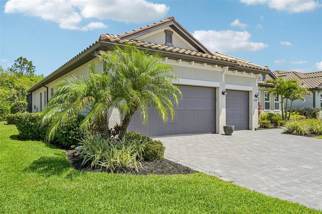 A single-story house with a gray garage, tile roof, and a palm tree in the yard — 16309 TRADEWIND TERRACE, LAKEWOOD RANCH, FL