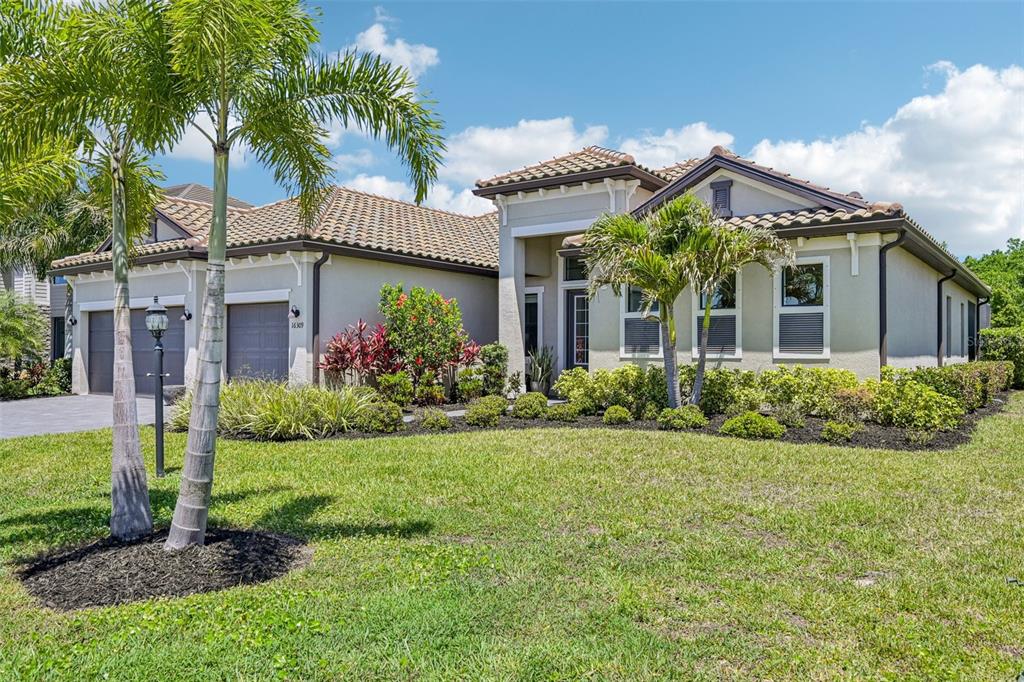 A single-story house with a tile roof, two-car garage, and palm trees in the front yard — 16309 TRADEWIND TERRACE, LAKEWOOD RANCH, FL