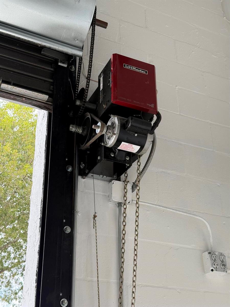 A LiftMaster commercial garage door opener is mounted on a white painted brick wall — 1777 Blount Road # 515, Pompano Beach FL 33069, POMPANO BEACH, FL