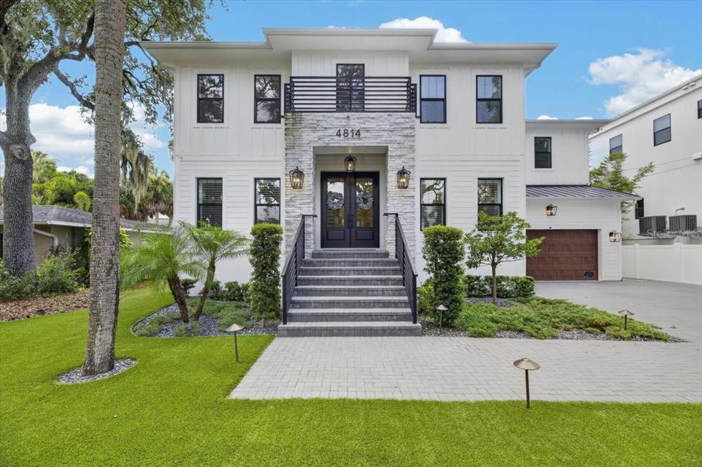 A two-story modern white house features a stone facade, black window frames, and a front staircase — 4814 W SAN JOSE STREET, TAMPA, FL