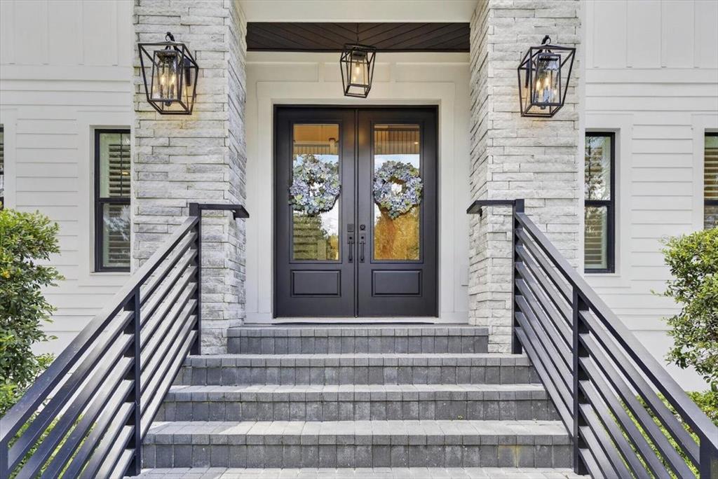 A front entrance features stone pillars, black double doors, and stairs with metal railings — 4814 W SAN JOSE STREET, TAMPA, FL