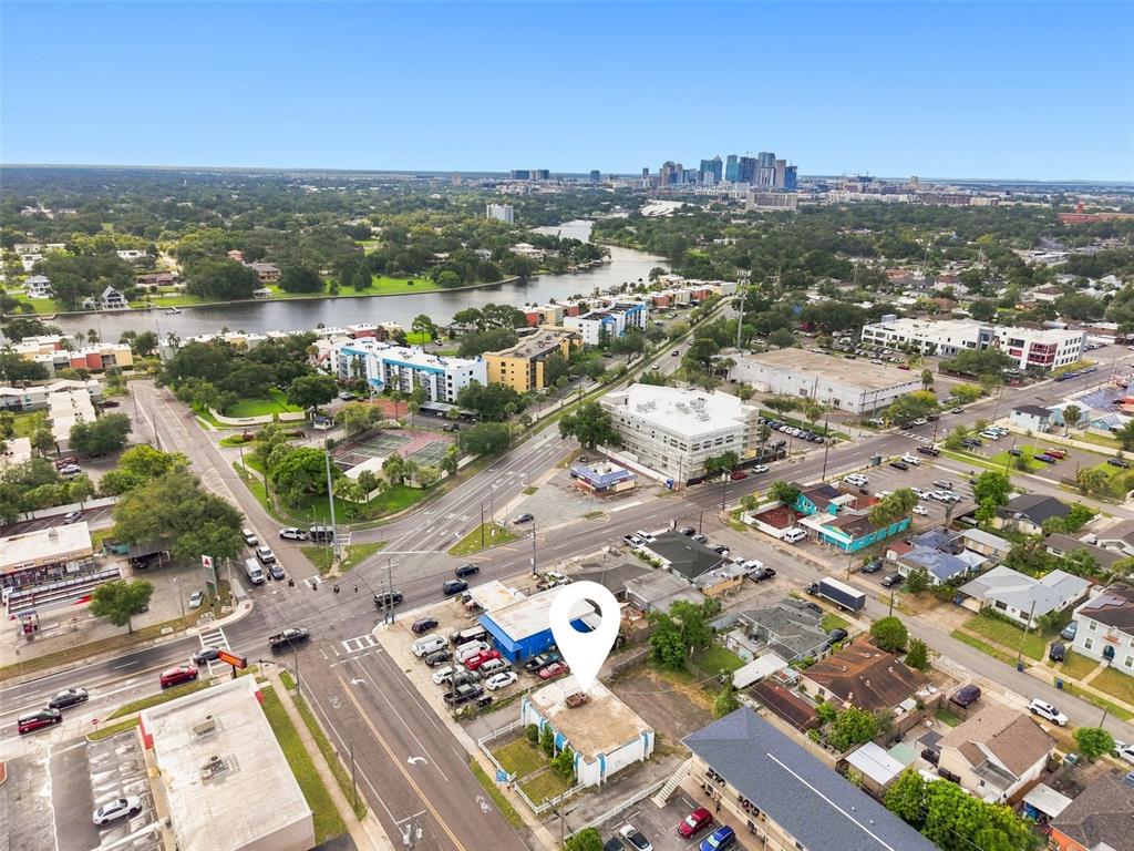 An aerial view shows a commercial building with a parking lot near a city skyline — 2508 W TAMPA BAY BOULEVARD, TAMPA, FL