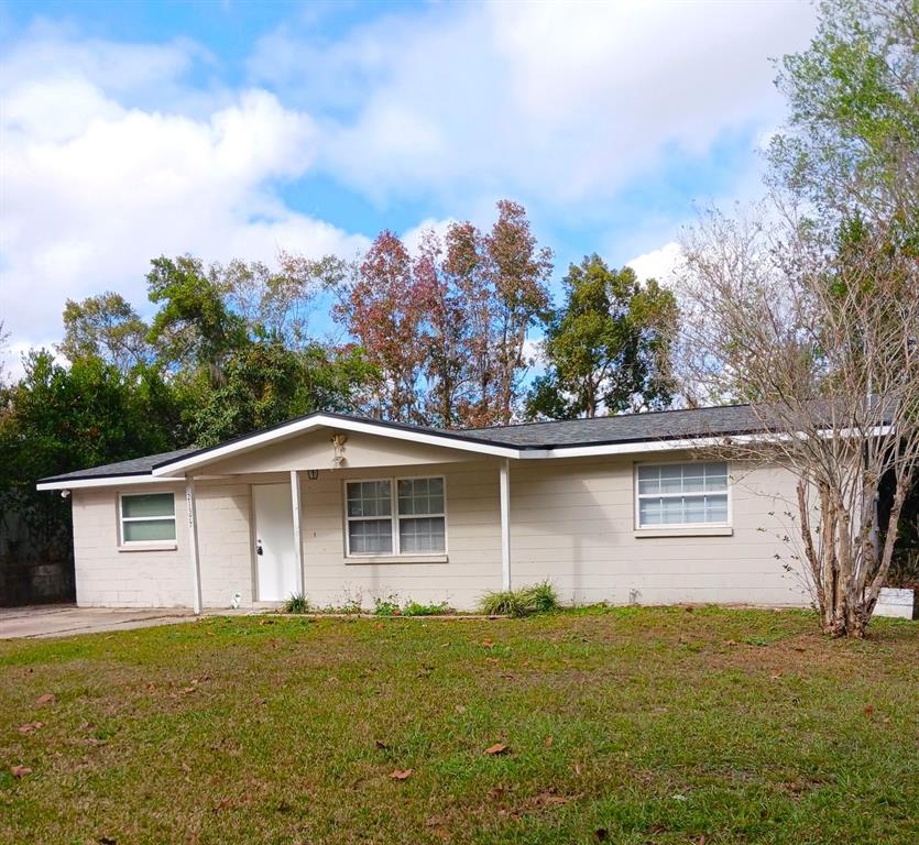 A single-story, light-colored house with a gabled roof, white trim, and a grassy front yard — 21377 CAMPBELL DRIVE, BROOKSVILLE, FL