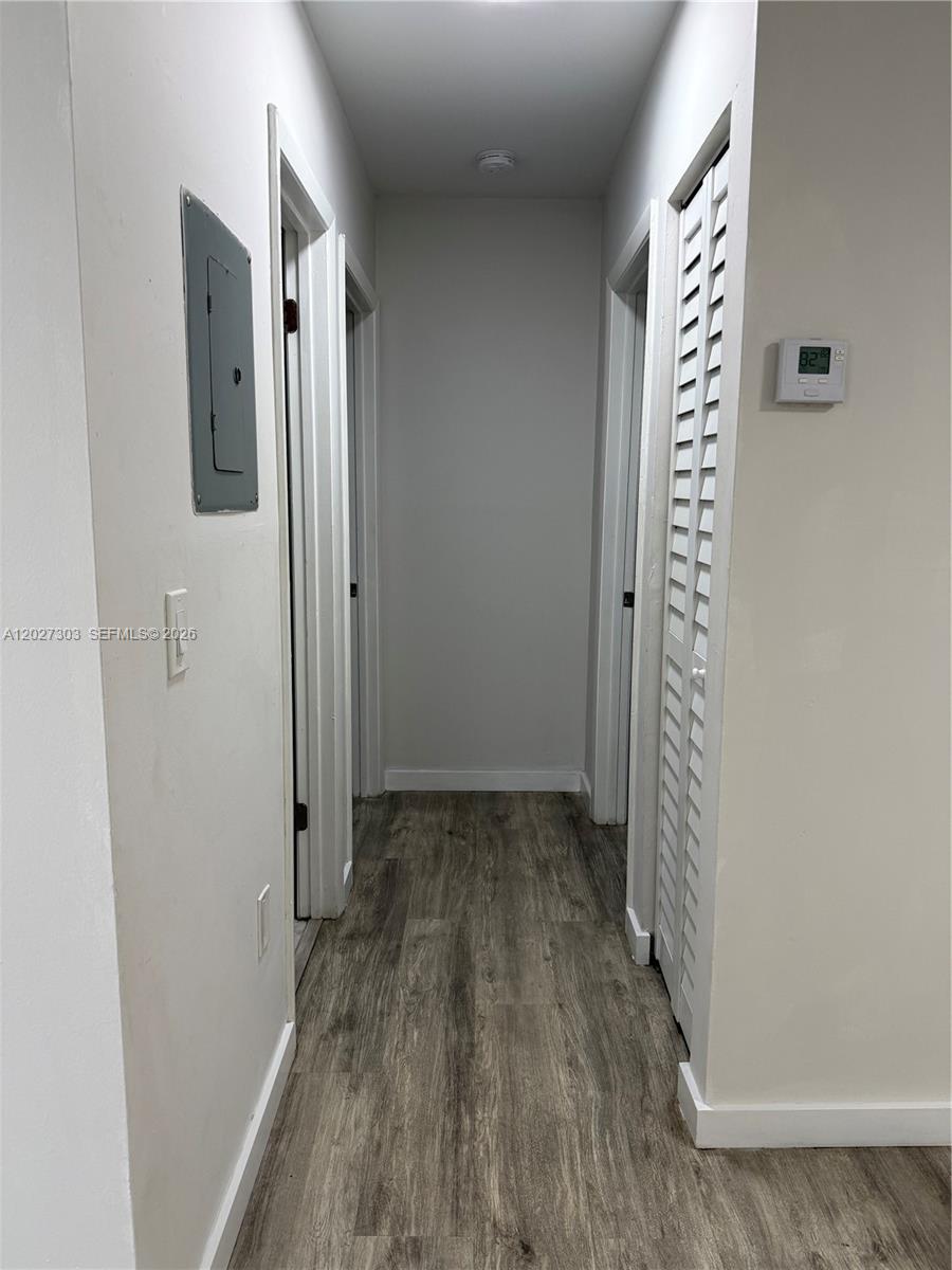 A hallway features light gray walls, wood-look flooring, a circuit breaker panel, and louvered doors — 1580 SW 2nd St # 4, Miami FL 33135, MIAMI, FL
