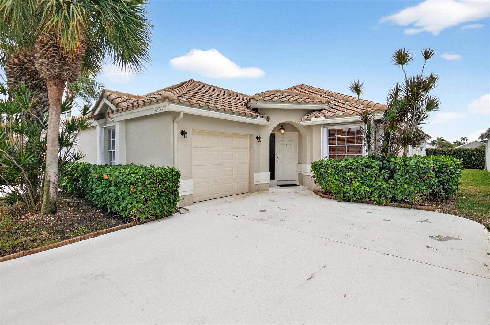 A stone monument sign for Lakeridge stands in a landscaped garden with palm trees — 6157 Bay Isles Drive, Boynton Beach FL 33437, BOYNTON BEACH, FL