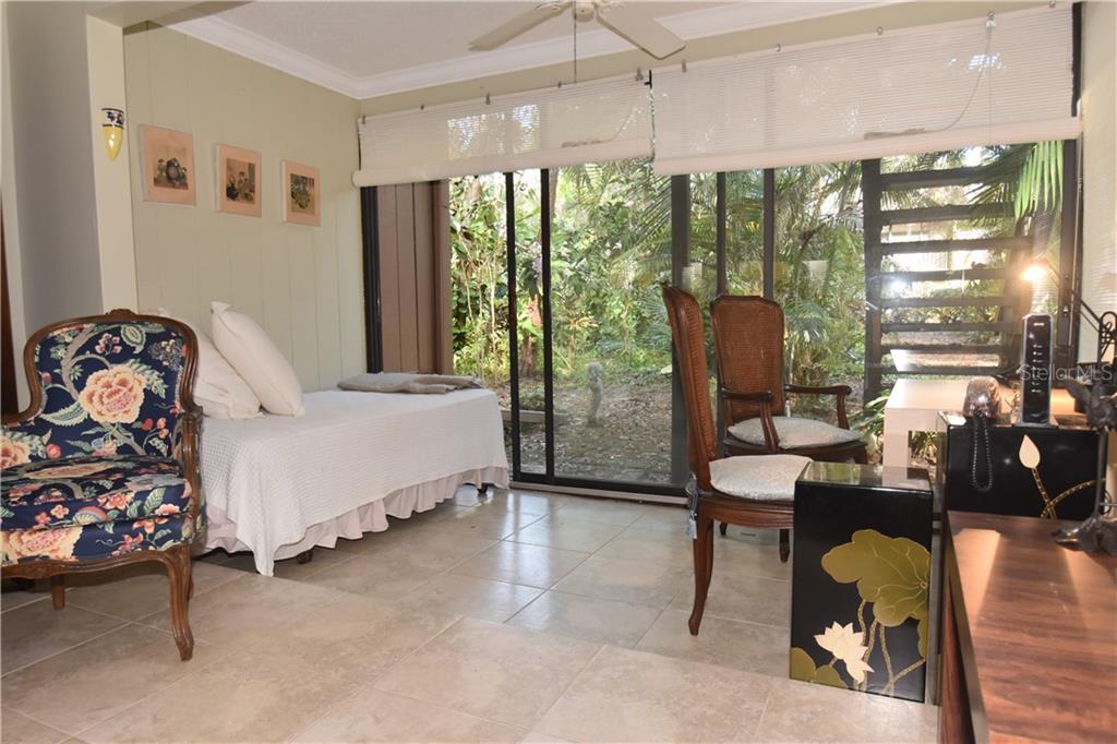 A room with tile floors, a daybed, two chairs, and sliding glass doors to a garden — 1716 GLENHOUSE DRIVE UNIT GL324, SARASOTA, FL