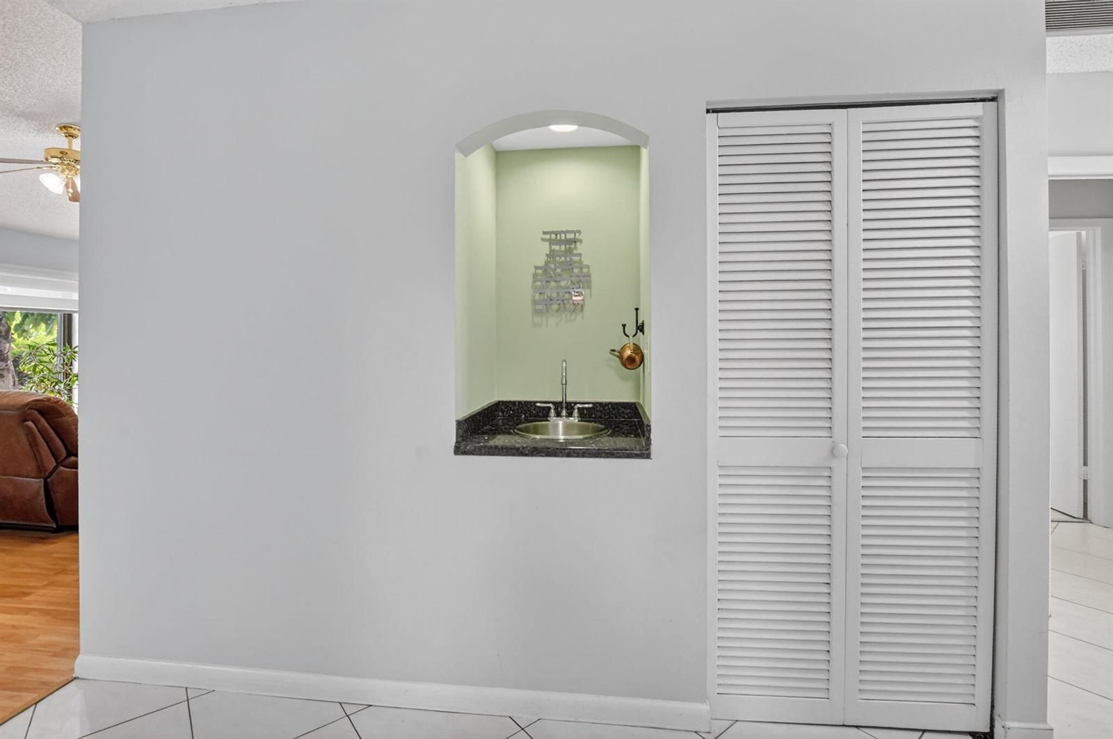 A wall features a recessed wet bar with a sink and a white louvered closet — 7833 San Marcos Place, Boca Raton FL 33433, BOCA RATON, FL