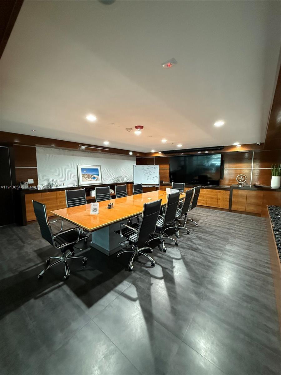 A conference room features a long wooden table, black chairs, and dark tile flooring — 9450 SW 72nd St, Miami FL 33173, MIAMI, FL
