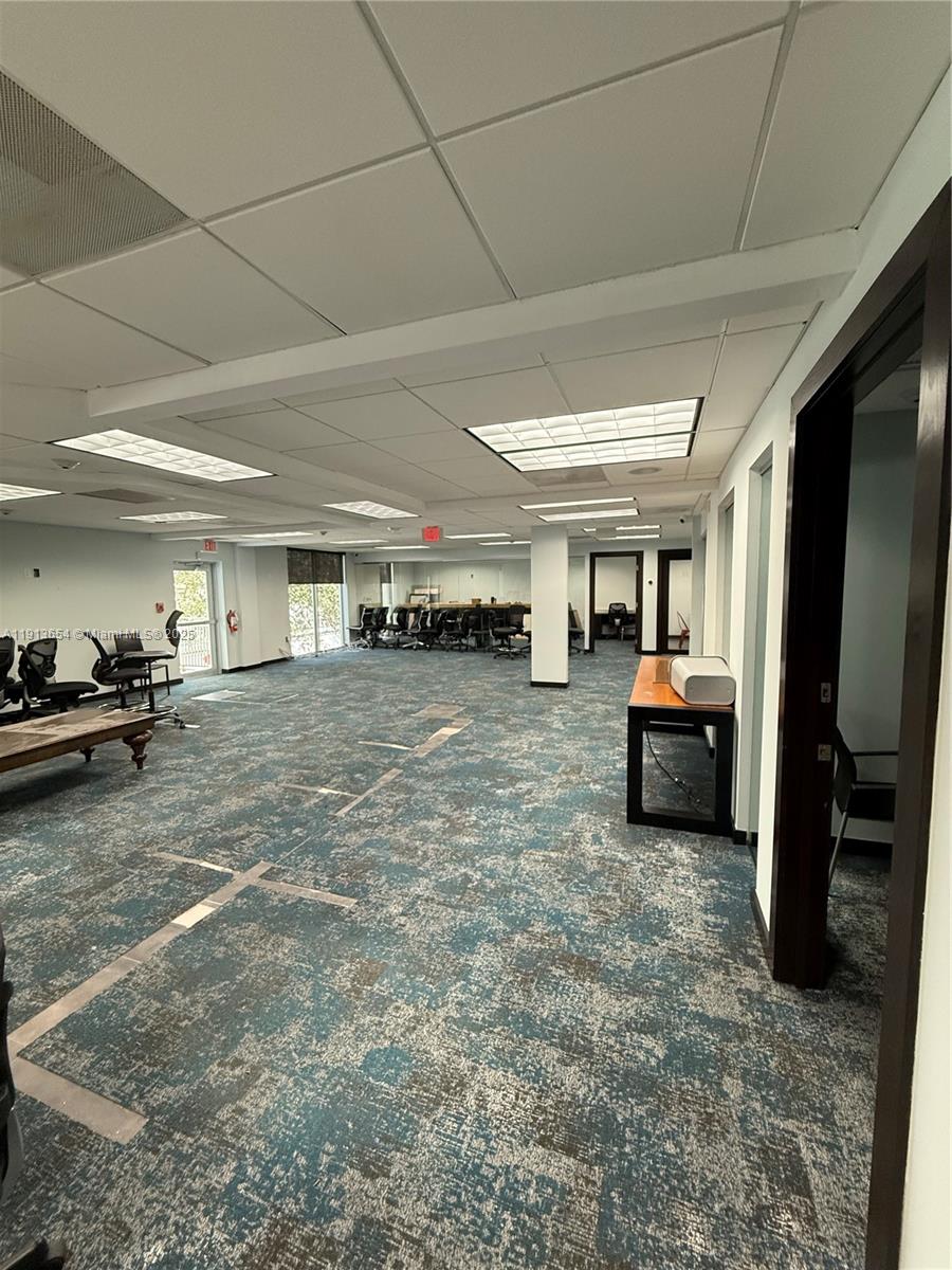 An office space features a patterned blue carpet, drop ceiling, and several workstations — 9450 SW 72nd St, Miami FL 33173, MIAMI, FL