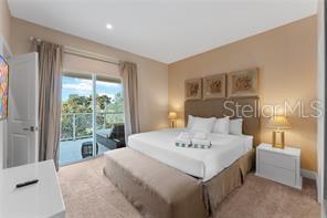 A bedroom features a king bed, a bench, two nightstands, and a sliding glass door — 3175 BRASILIA AVENUE, KISSIMMEE, FL