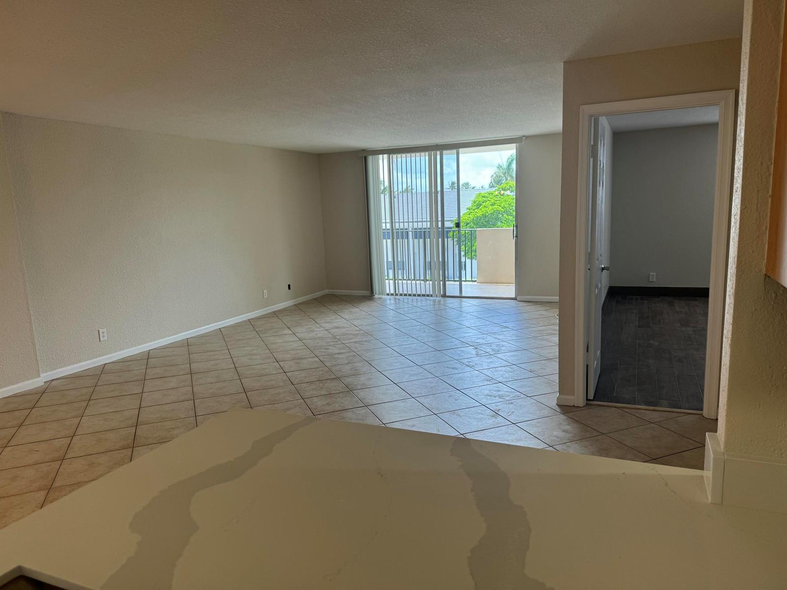 A kitchen features wood cabinets, a white countertop, and a stainless steel refrigerator — 1000 Spanish River Road # 3b, Boca Raton FL 33432, BOCA RATON, FL