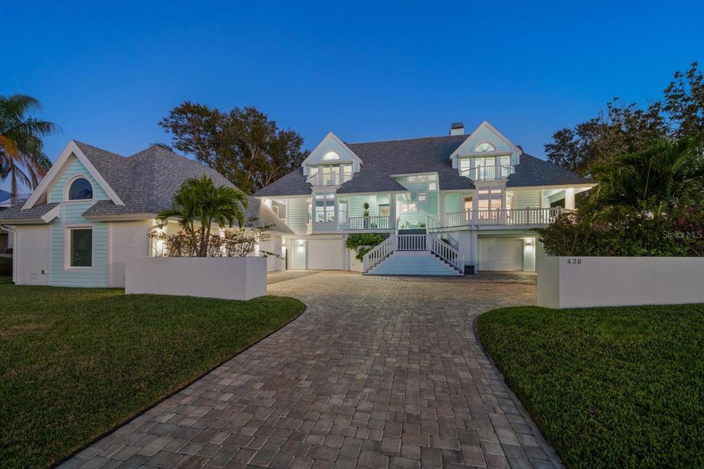 A large, light blue, multi-story house with a paved driveway and a central staircase — 430 ST ANDREWS DRIVE, BELLEAIR, FL