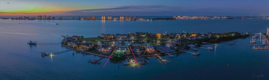 An aerial view of a waterfront property at dusk with a private dock and pool — 430 ST ANDREWS DRIVE, BELLEAIR, FL