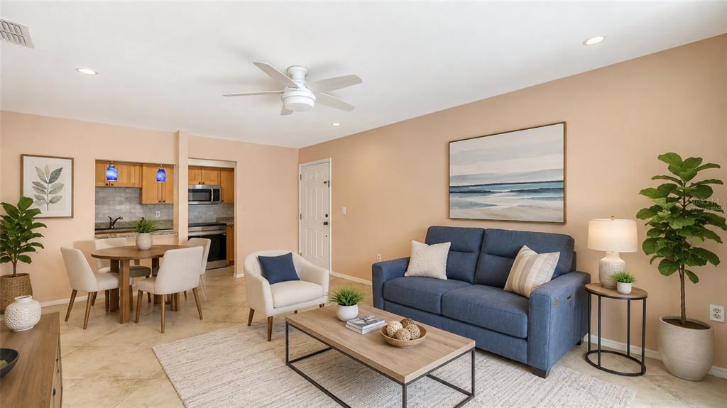 A living room and dining area with tile floors, a blue sofa, and wooden furniture — 631 N ORANGE AVENUE UNIT 208, SARASOTA, FL