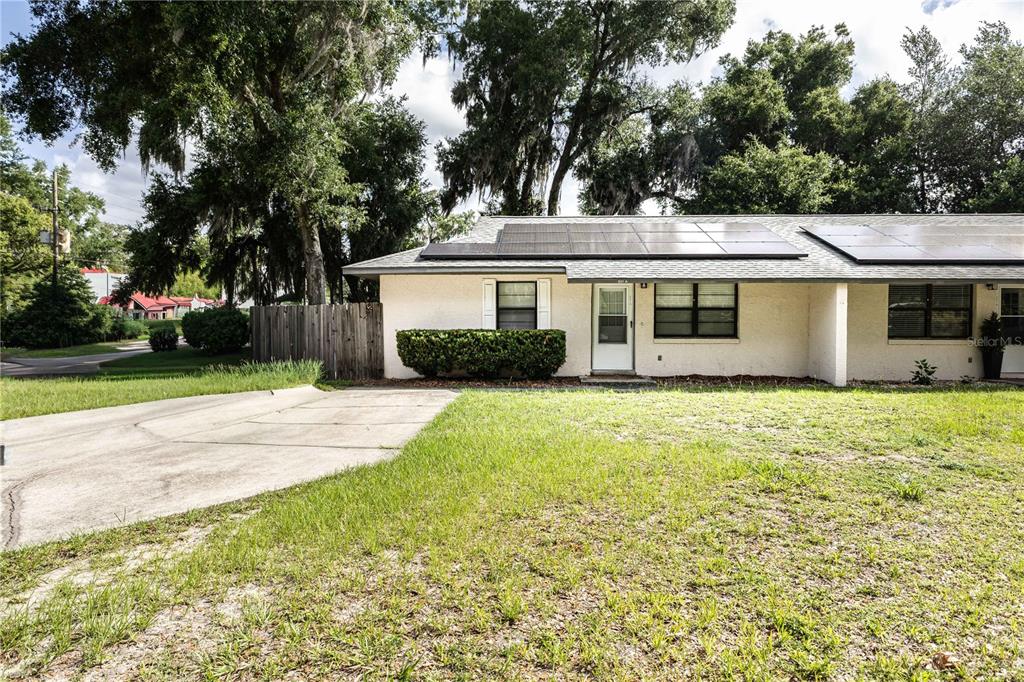 A single-story house with solar panels on the roof and a concrete driveway — 301 CURRY STREET, WILDWOOD, FL