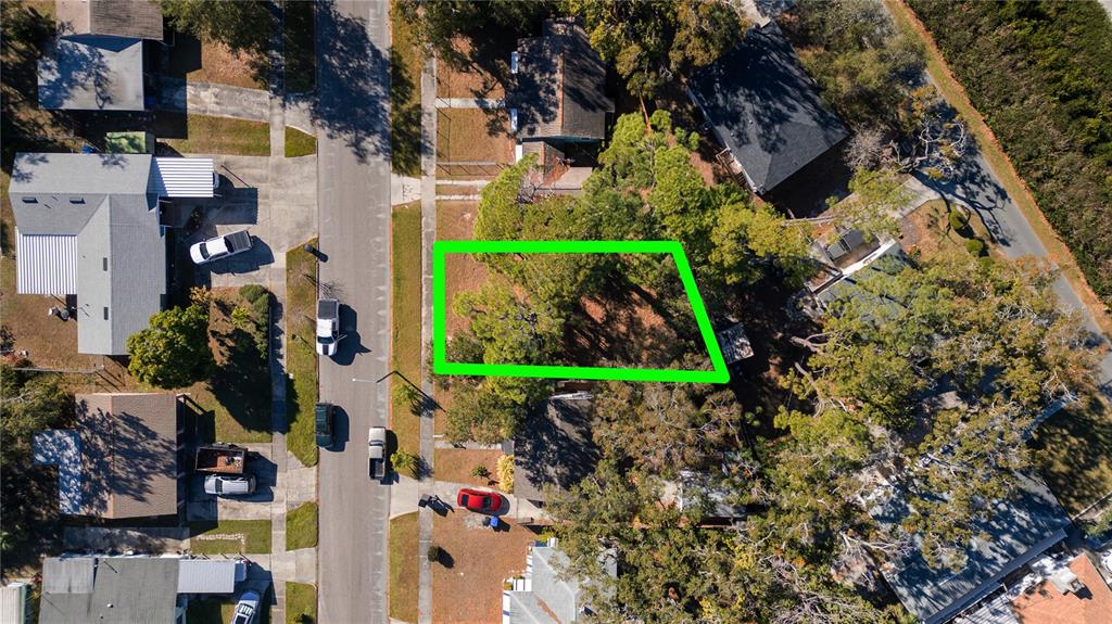 An aerial view shows a vacant, tree-covered residential lot outlined in green — 26TH AVENUE S, ST PETERSBURG, FL