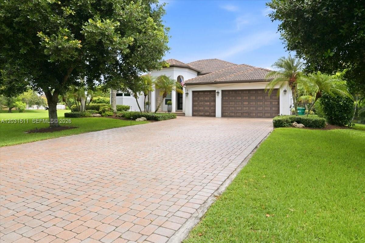 A single-story house with a paved driveway, two-car garage, and mature landscaping — 12160 NW 18th St, Plantation FL 33323, PLANTATION, FL
