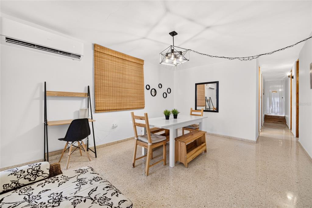 A dining area features a white table, wooden chairs, a bench, and a desk nearby — C10 CALLE 5, LUQUILLO, PR