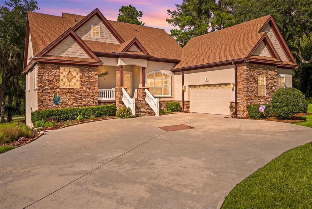 A two-story house with a stone facade, brown shingled roof, and a concrete driveway — 1706 SW 27TH STREET, OCALA, FL