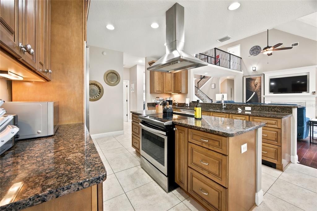 A kitchen with wood cabinets, granite countertops, stainless steel appliances, and a central island — 1706 SW 27TH STREET, OCALA, FL