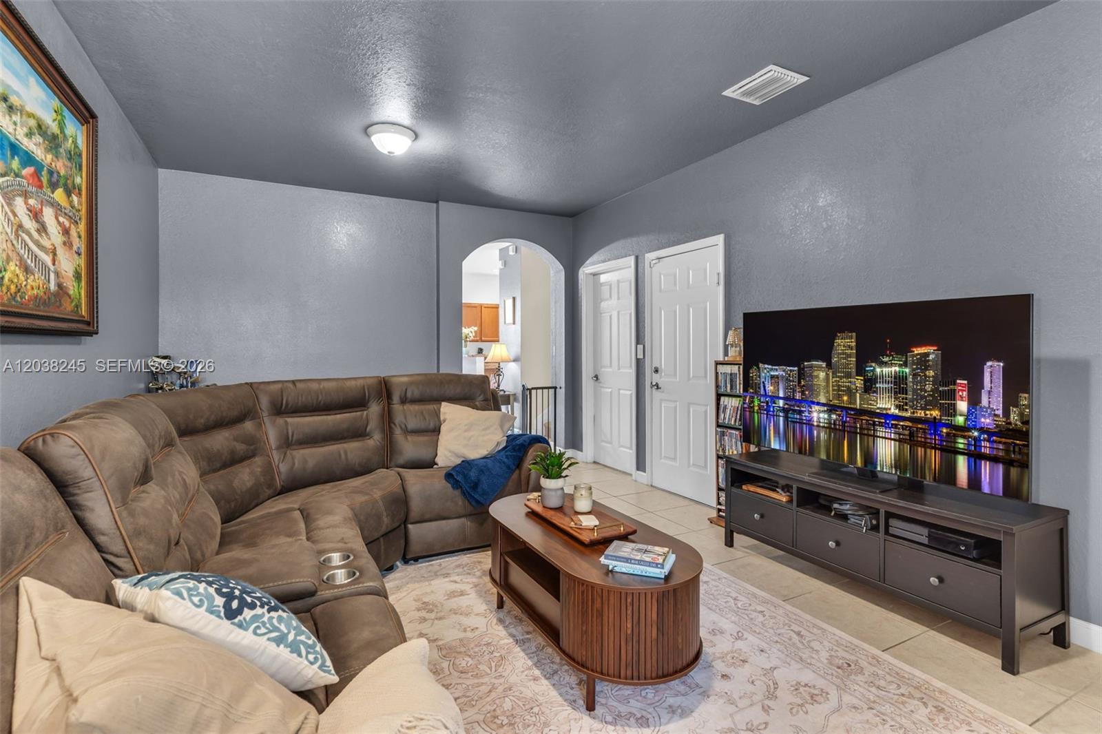 A living room features a brown sectional sofa, a coffee table, and a television console — 23357 SW 113th Psge, Homestead FL 33032, HOMESTEAD, FL
