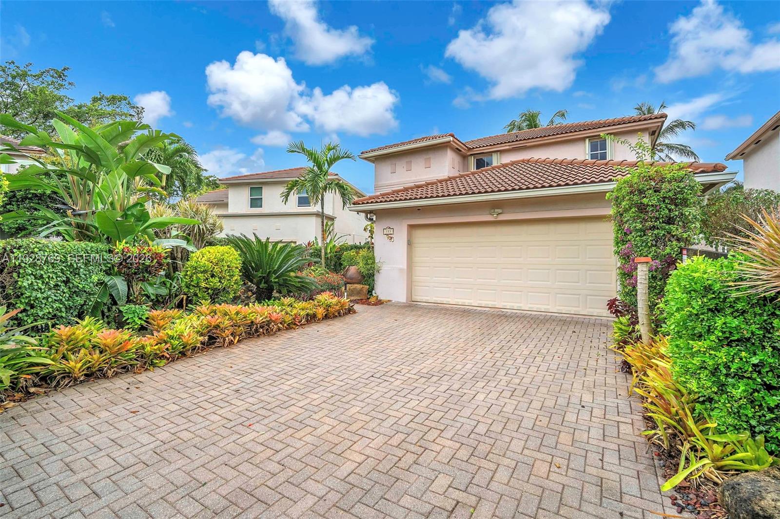 A two-story house with a beige garage door and a brick driveway surrounded by landscaping — 113 NW 73rd Ter, Plantation FL 33317, PLANTATION, FL