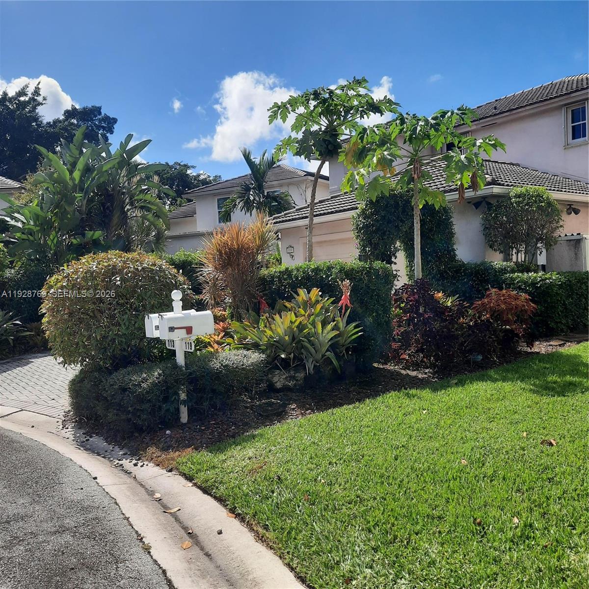 A residential house exterior features a landscaped front yard with a mailbox and papaya trees — 113 NW 73rd Ter, Plantation FL 33317, PLANTATION, FL