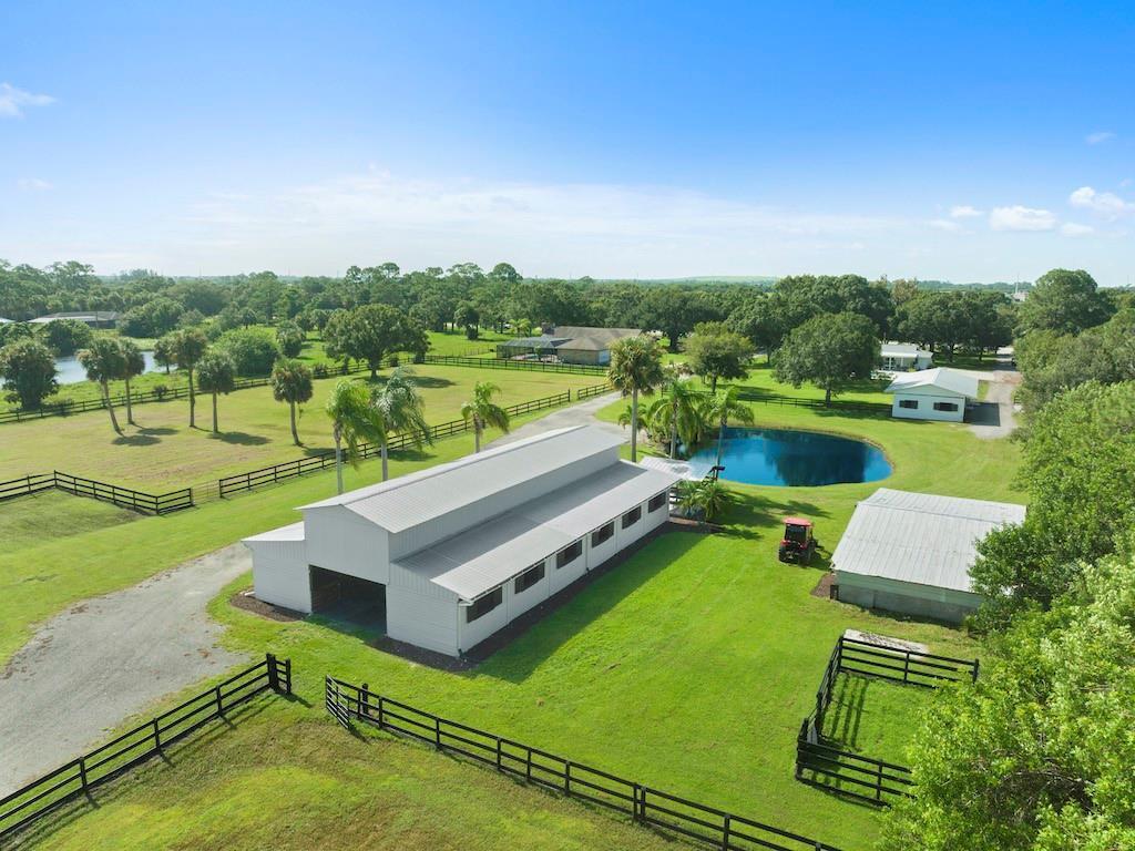 An aerial view shows a metal barn, a small pond, and fenced pastures on a property — 8530 8th Street, Vero Beach FL 32968, VERO BEACH, FL