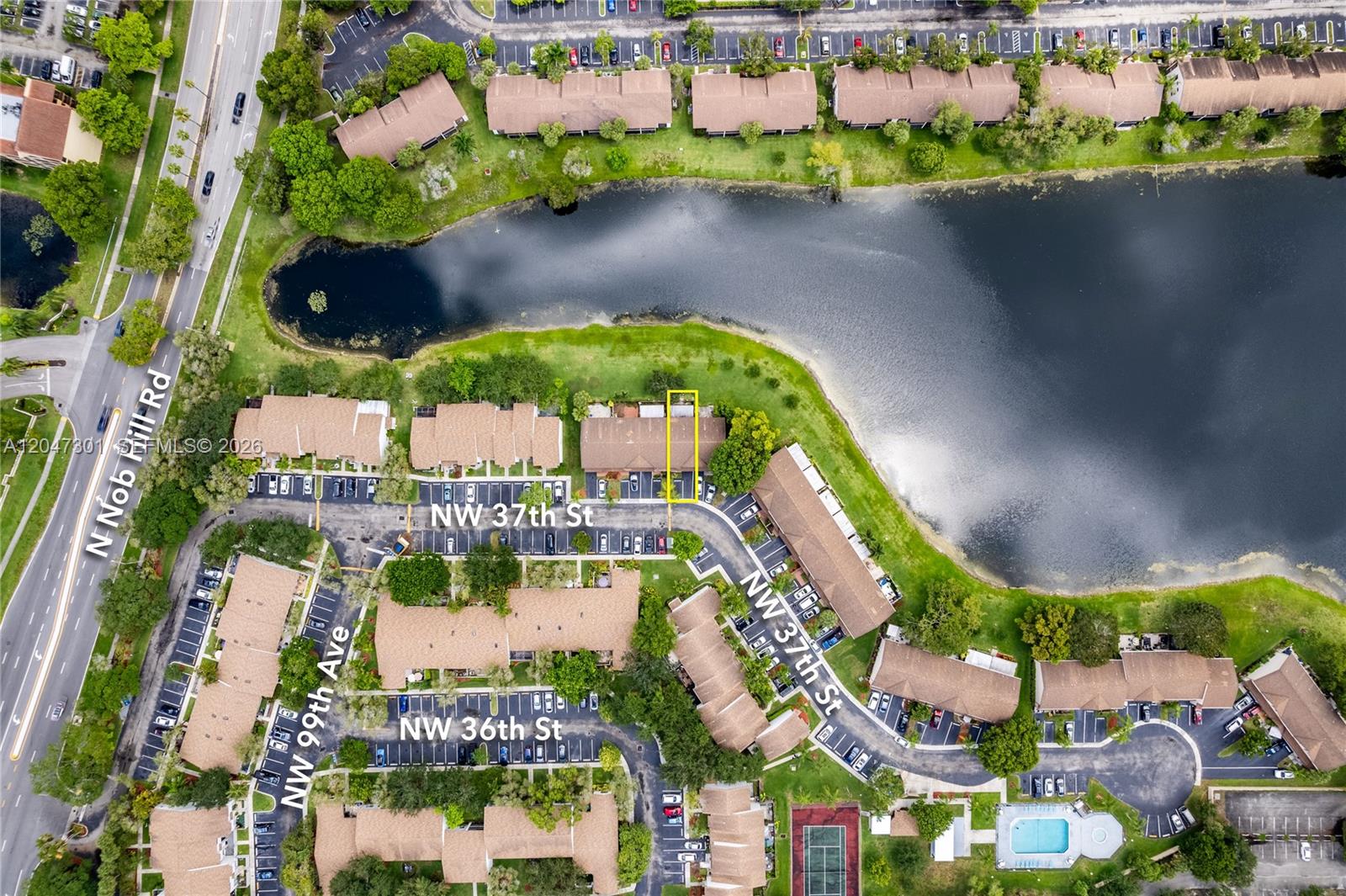This aerial view shows a residential townhouse complex with a lake and parking lots — 9803 NW 37th St, Sunrise FL 33351, SUNRISE, FL