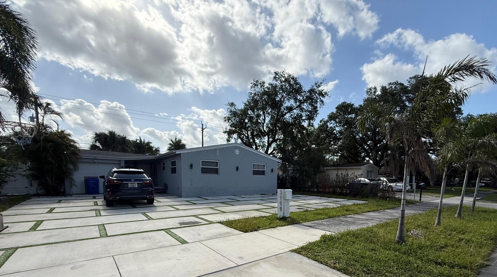 A gray single-story house features a large concrete paver driveway with grass strips — 3111 N 66th Avenue, Hollywood FL 33024, HOLLYWOOD, FL