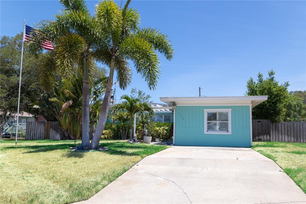 A turquoise house with a concrete driveway and a palm tree in the front yard — 136 MARYLAND AVENUE, PALM HARBOR, FL